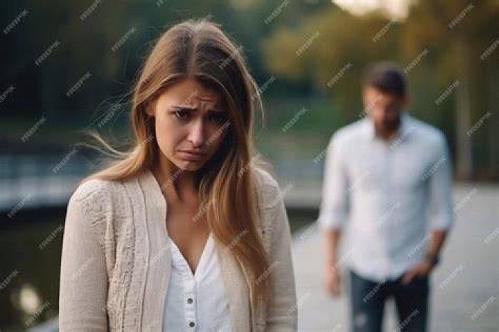 A sad woman cries after reading messages on her cell phone | Source: Shutterstock