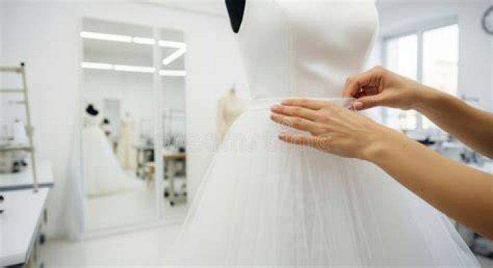 A wedding dress designer working on a dress | Source: Pexels