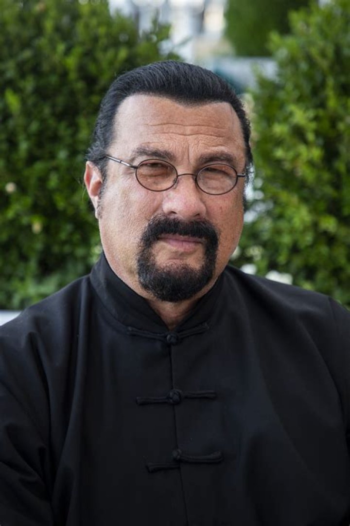 Actor and screenwriter Steven Seagal posing while resting his hand on his chin, wearing a black suit on May 8, 1995 in Milan. / Source: Getty Images