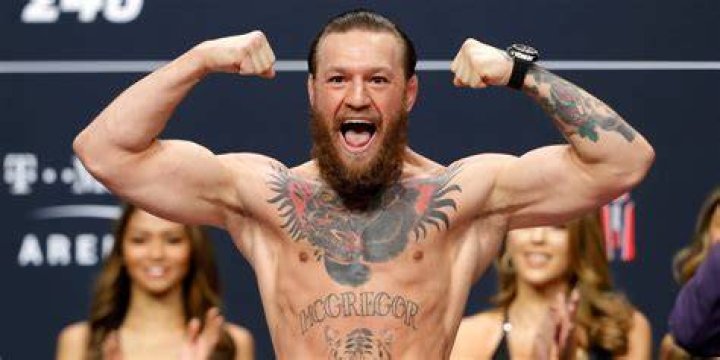 Conor McGregor showing off his Featherweight and Lightweight championship belts during the UFC 205 press conference at Madison Square Garden on November 10, 2016 | Photo: Getty Images