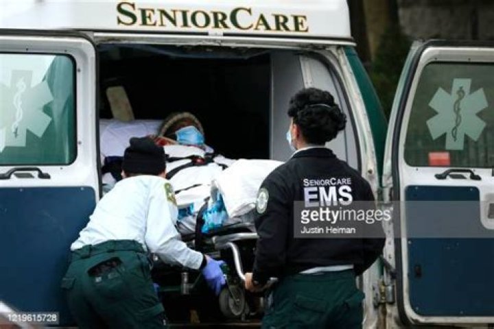Emergency Medical Service workers unload a patient into their ambulance at the Cobble Hill Health Center in April. Cuomo's office is accused of hiding nursing home death data