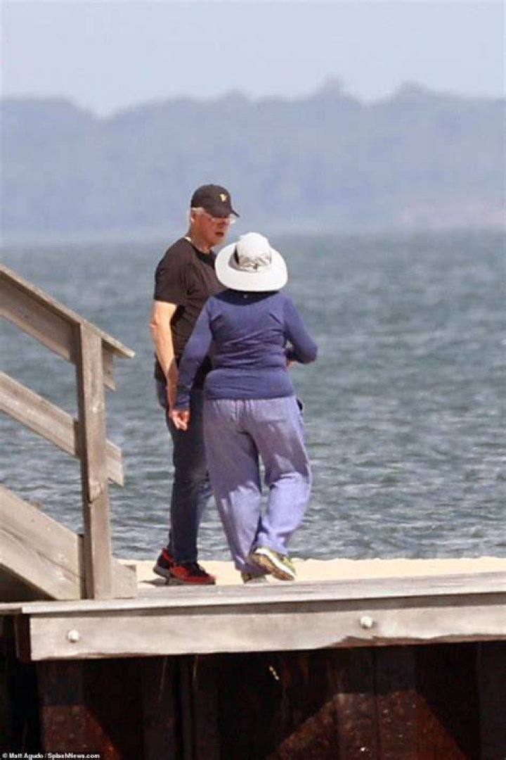 The Clintons spotted taking a walk along the beach near their home in The Hamptons.