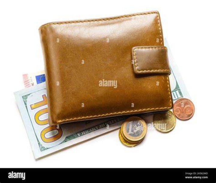 Wallet with banknotes and coins on table | Source: Unsplash
