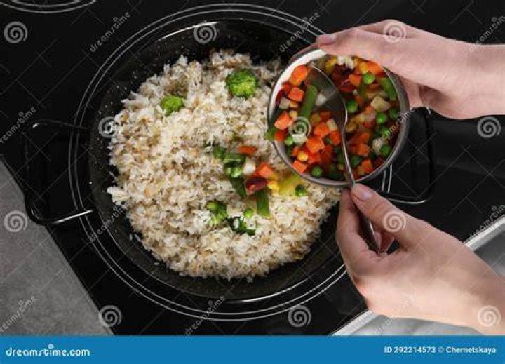 woman cooking rice and vegetables